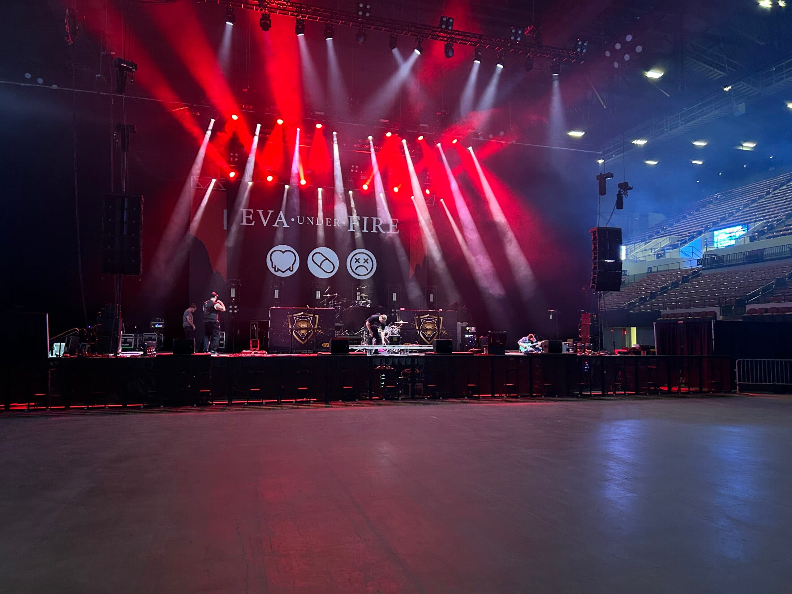 Arena stage lit in red under full production lighting